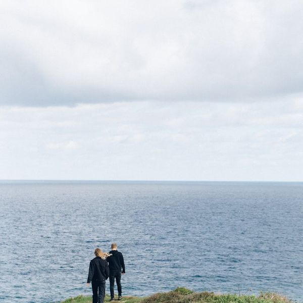 A man stretching outdoors with a serene landscape in the background.